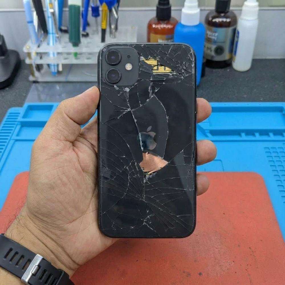 iPhone con tapa trasera completamente rota antes de la reparación